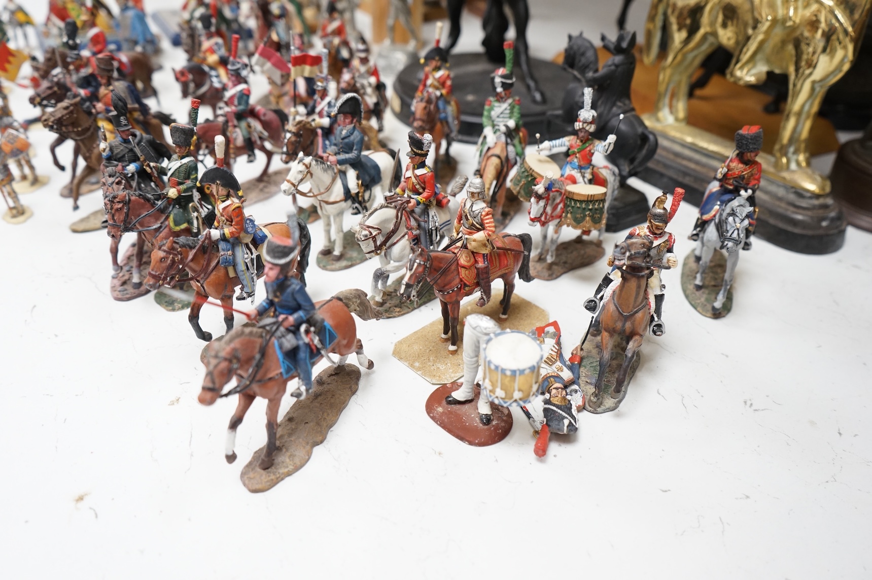 A pair of spelter figures a brass door stop two models of horses two other figures and a large group of toy soldiers. Tallest 45cm.